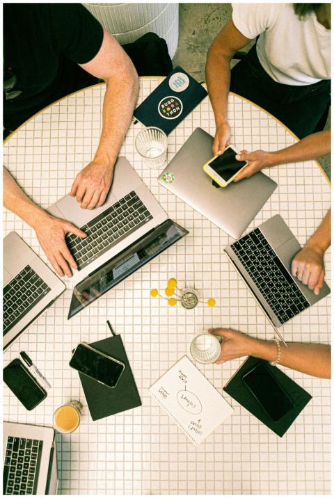 Top view of a team collaborating with laptops, pho