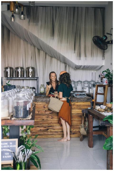 Two women interacting at a zero waste store counte