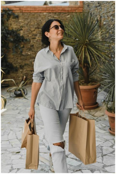 Stylish woman with sunglasses carrying shopping ba