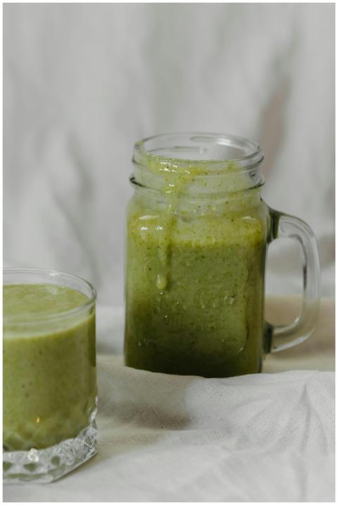 Fresh green smoothie in a mason jar and glass, per