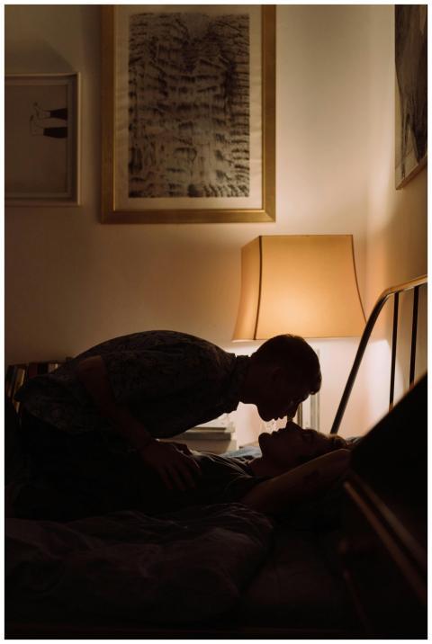 Silhouette of a couple in a dimly lit bedroom shar