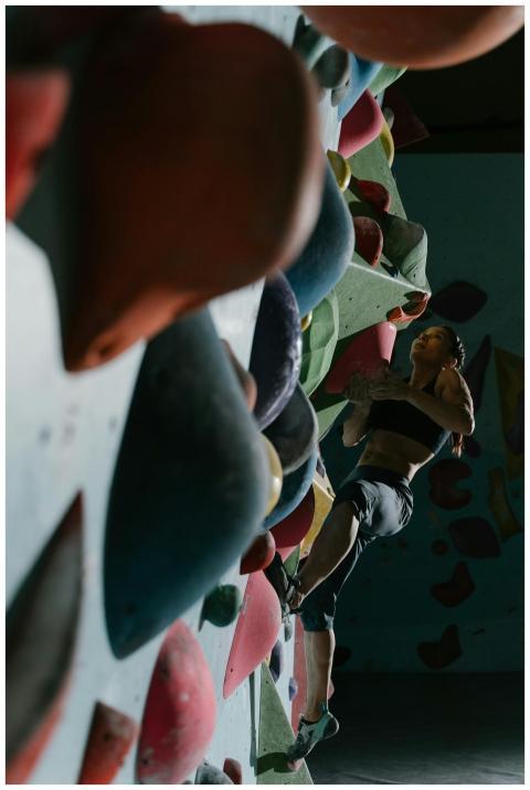 A skilled woman tackling an indoor bouldering chal