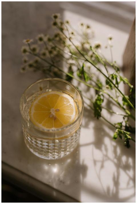 Elegant drink with lemon slice in crystal glass on