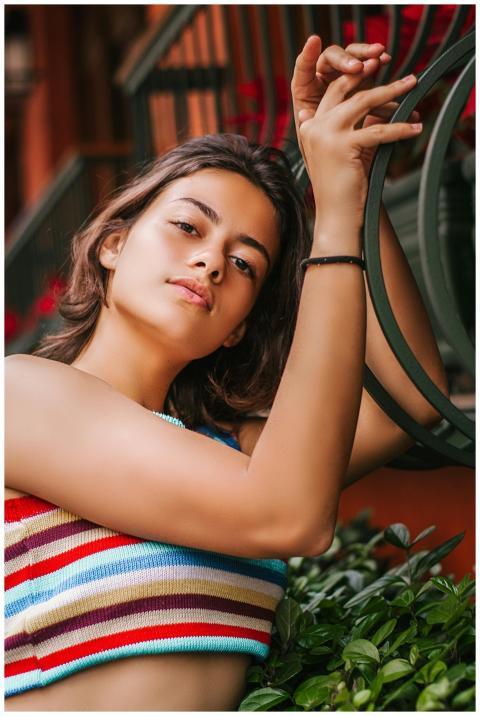 Portrait of a young woman in a colorful top posing