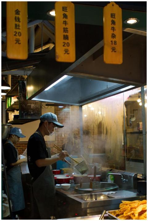 A cook prepares traditional Chinese noodles in a b