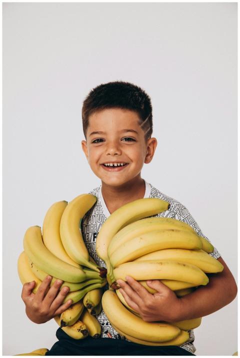Cheerful young boy smiling while holding fresh rip