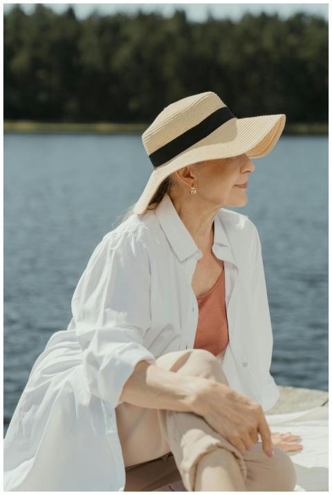 Senior woman in fashionable attire relaxing by a s