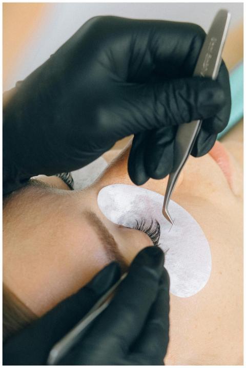 Close-up of eyelash extension application with bla