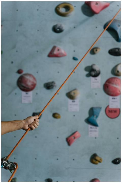 Close-up of a hand holding a belay rope indoors wi