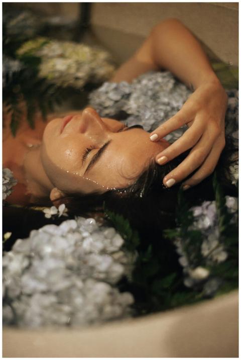 Peaceful woman bathing surrounded by flowers, enjo