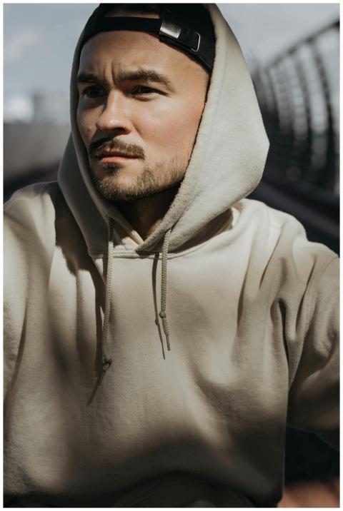 Portrait of a man in a beige hoodie with a backwar