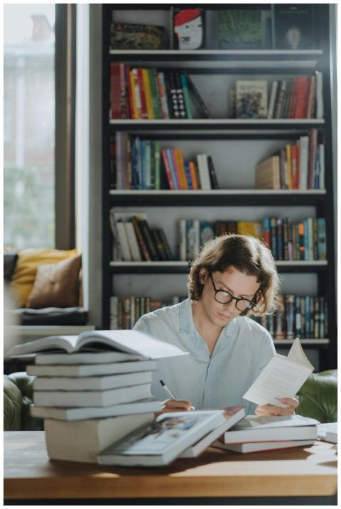 A young man focuses on studying amidst a bookstore