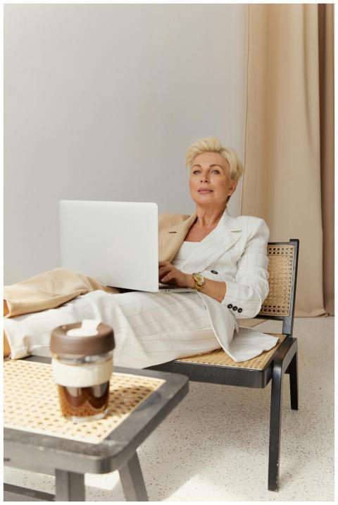 A professional woman in a blazer relaxes while wor