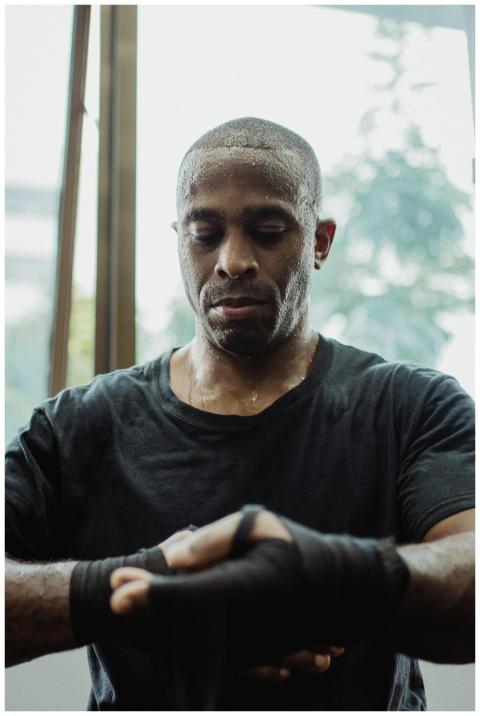 A determined athlete in a gym setting, wrapping ha