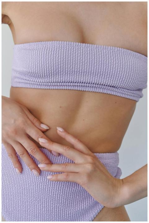 Close-up of a woman's midsection in lilac swimwear