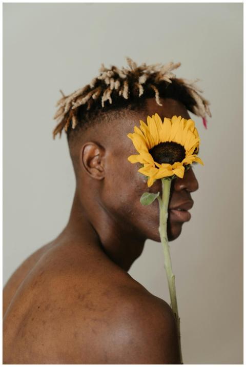 Conceptual portrait of a man with dreadlocks holdi