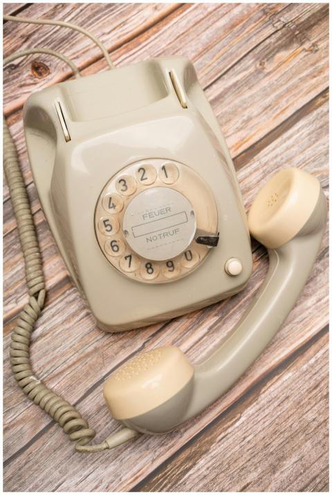 Retro rotary telephone placed on a rustic wooden t