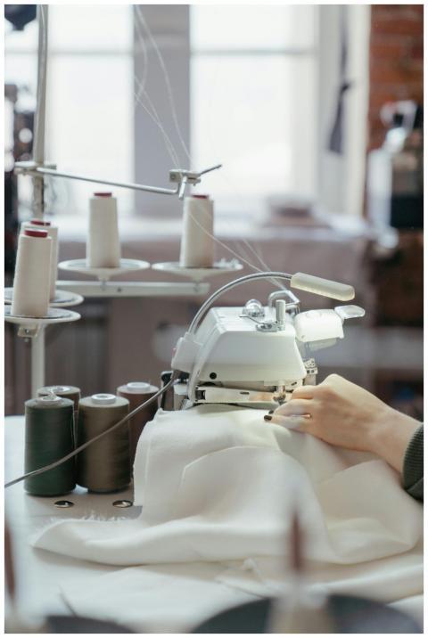 A person sewing fabric on a professional machine i
