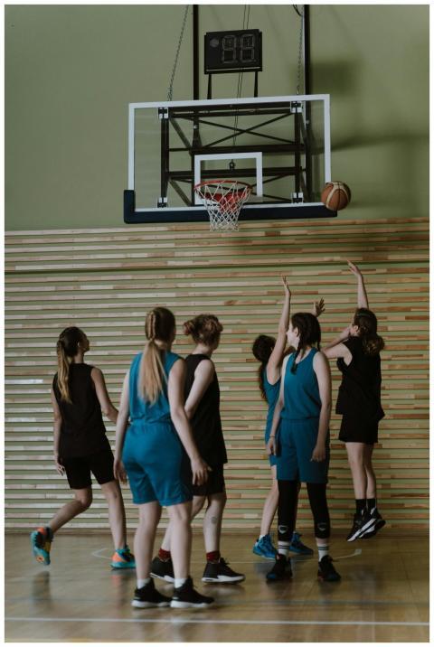 A group of women playing basketball in an indoor c