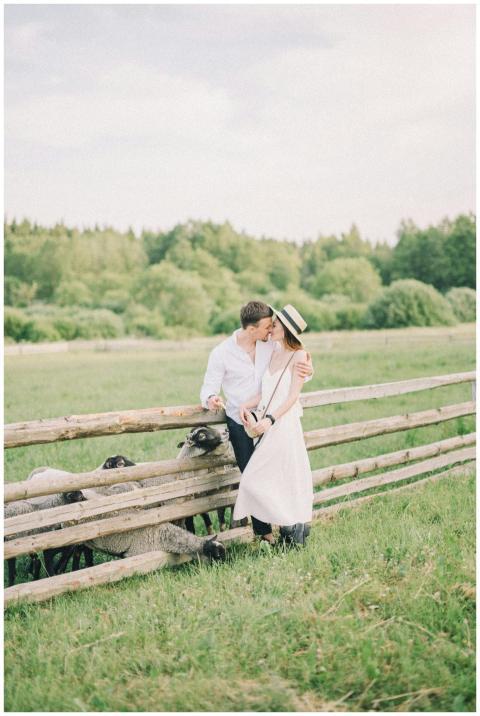 Romantic couple embracing by a fence on a summer p