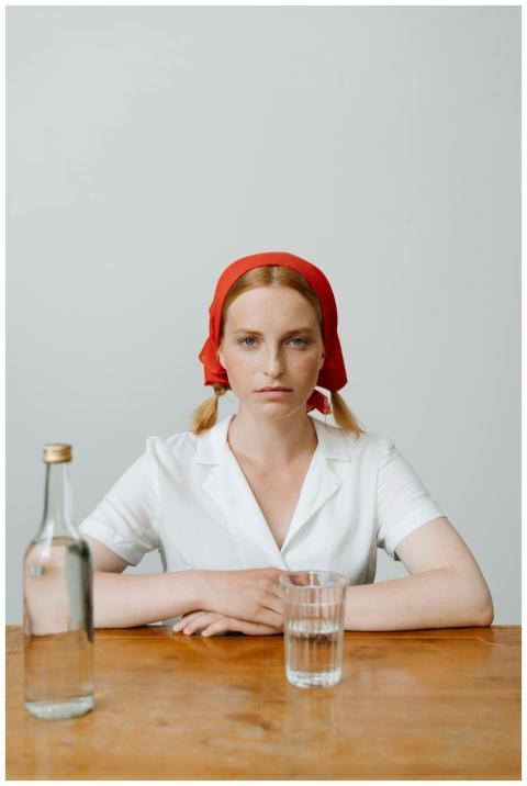 Redhead woman in white outfit with red kerchief at