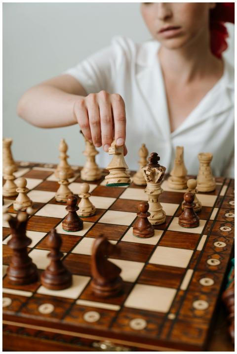 Close-up of a woman's hand making a strategic ches