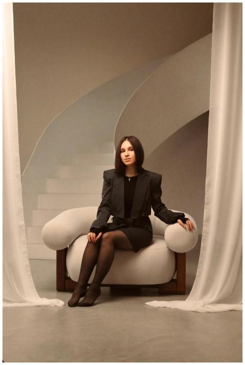 Stylish woman in a blazer sitting elegantly in a m