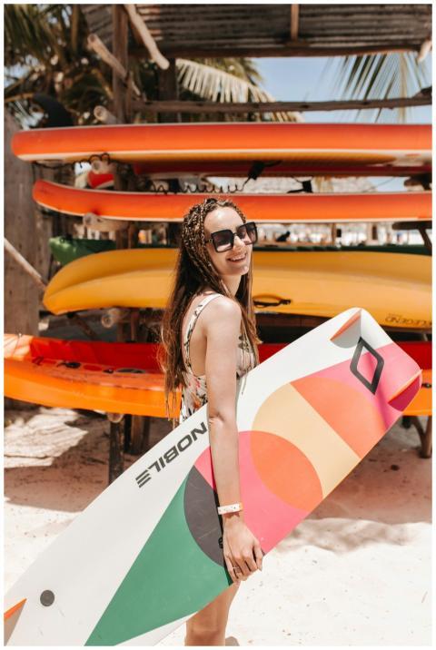 Smiling woman in sunglasses holding a colorful sur