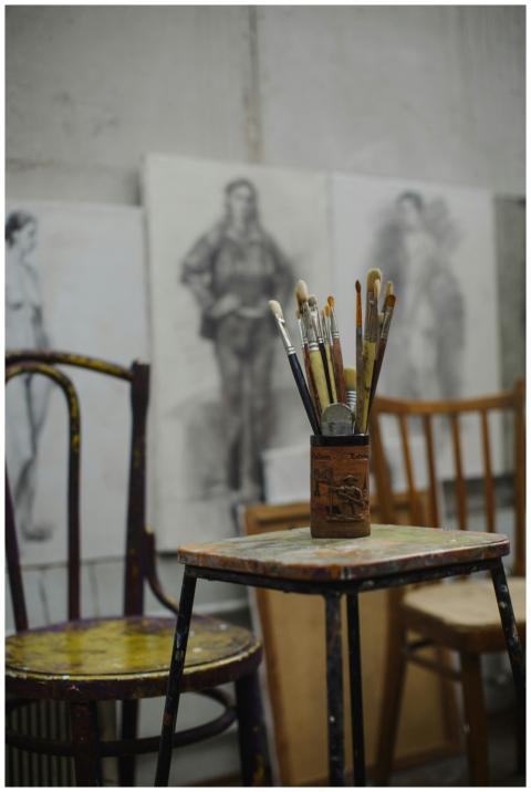 A cozy art studio scene featuring paintbrushes and