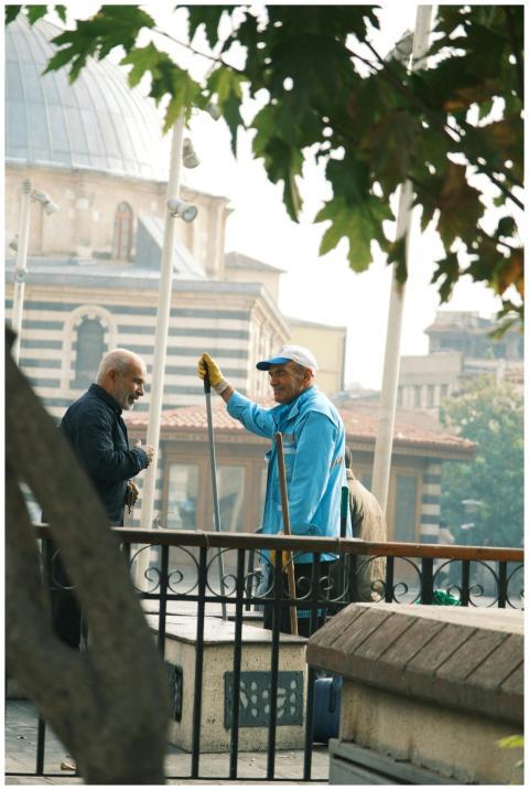 Two men talking near a historic building, outdoors