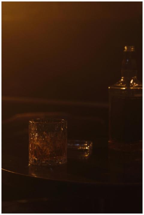 A dimly lit evening scene featuring a whiskey glas