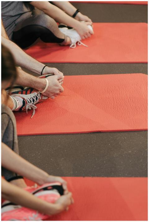 Participants stretch on red yoga mats, focusing on