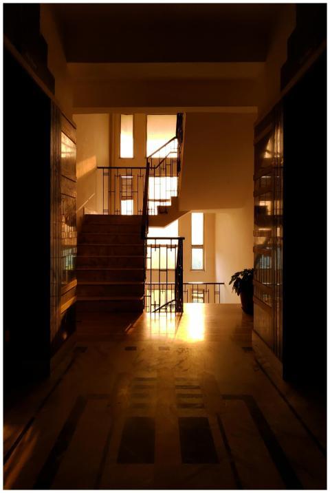 A hallway with stairs basked in golden sunset ligh