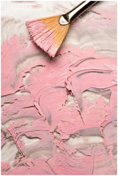 Vertical shot of textured pink paint with a brush