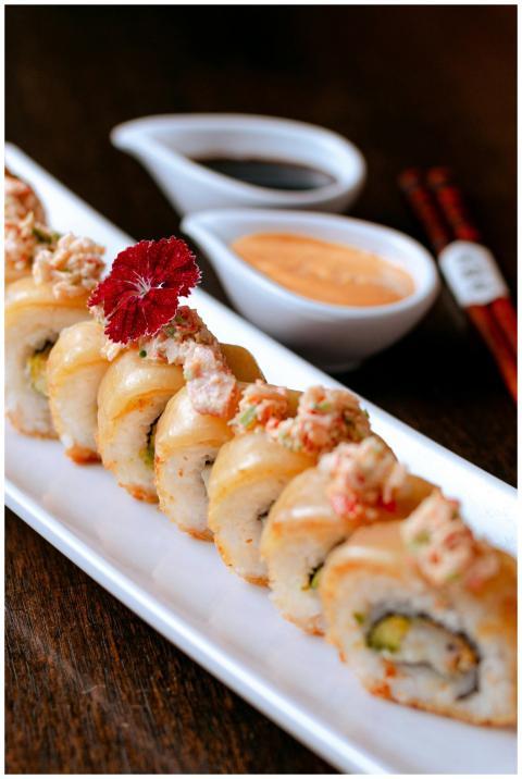 Delicious sushi rolls topped with garnish, served