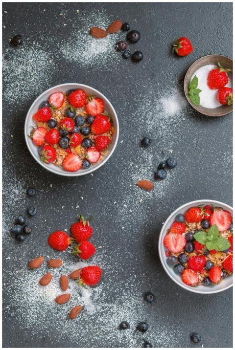 Top view of fresh berry and nut muesli bowls on a
