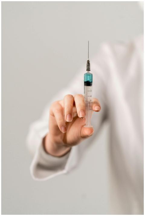 Detailed image of a hand holding a vaccine syringe