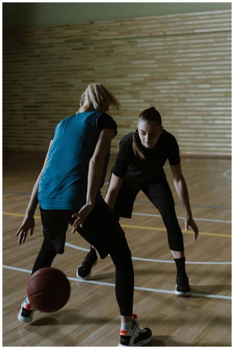 Two women playing an intense game of basketball in
