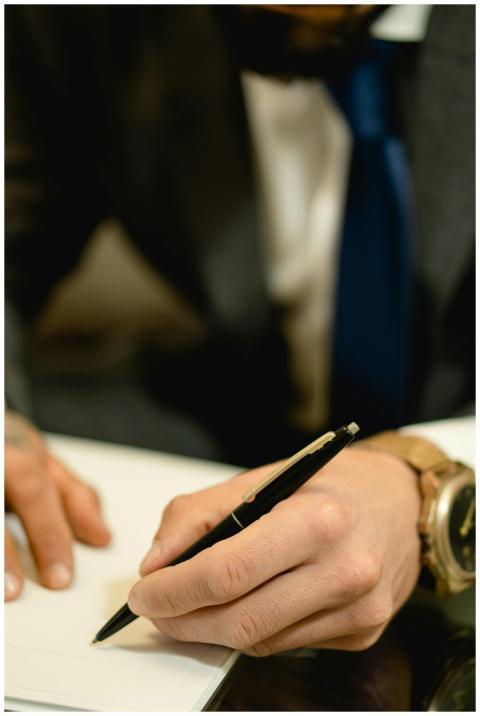 Close-up of hand signing a legal contract with a p