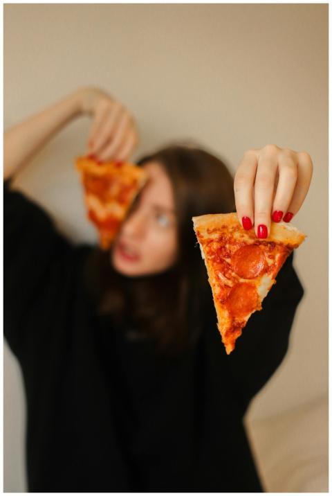 An artistic close-up of a woman holding a pepperon