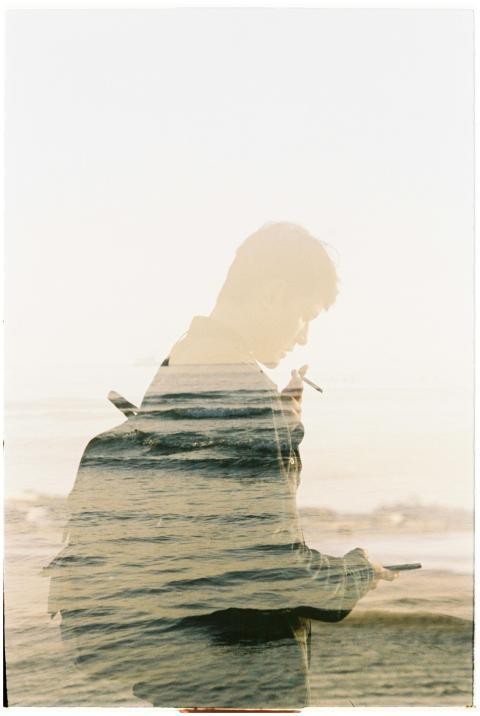 Artistic double exposure of a man smoking by the s