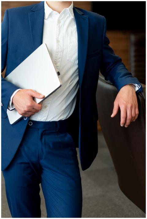 Business professional in blue suit holding a lapto