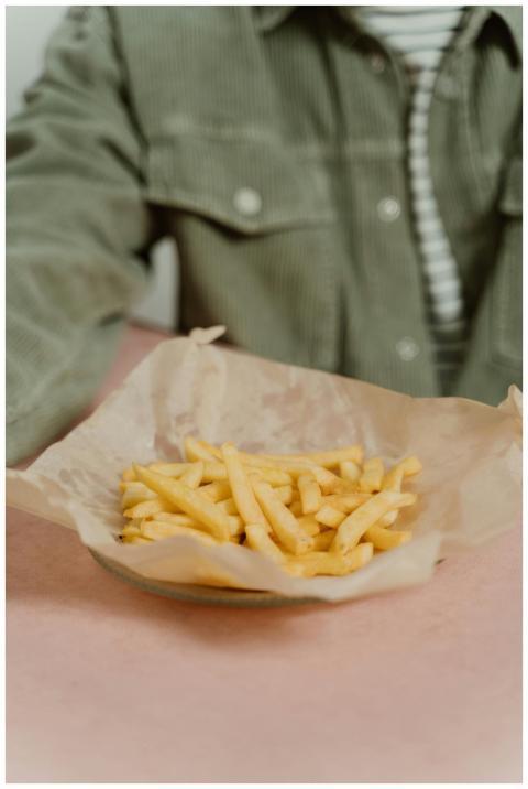 Close-up of crispy golden french fries on parchmen