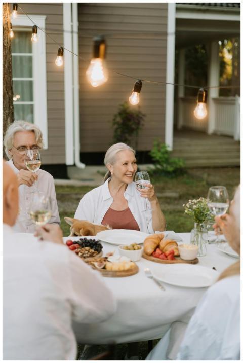 Seniors enjoying a festive dinner party outdoors w
