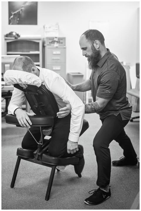 Massage therapist assisting client in a clinical s