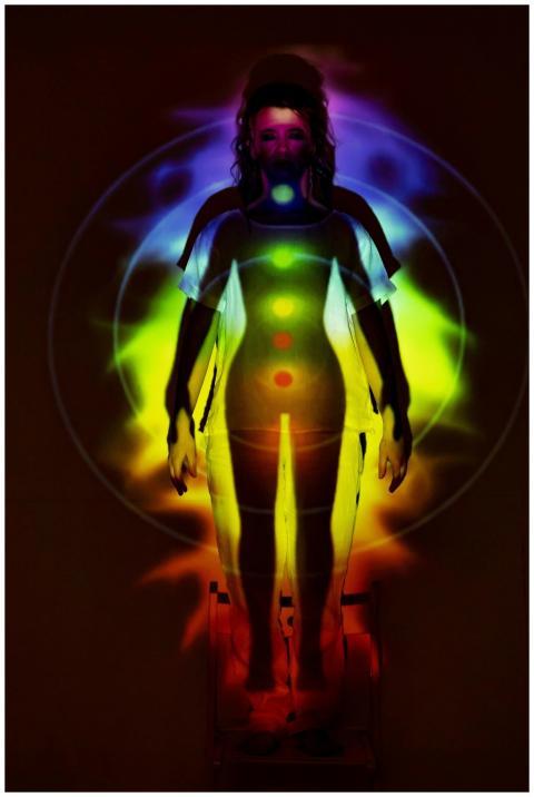 Human silhouette with vibrant chakra energy projec
