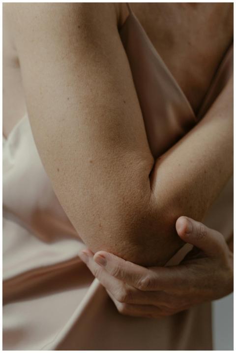 A soft focus close-up of a person's arm touching t