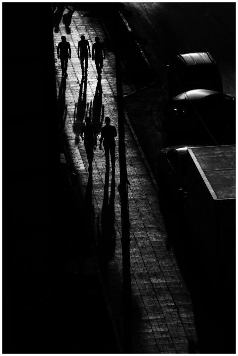 Black and white scene of people casting shadows on