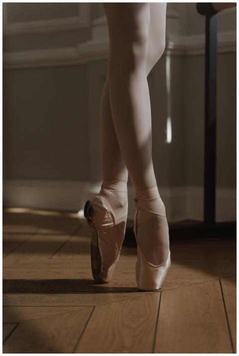 A ballerina in pointe shoes gracefully poses in a