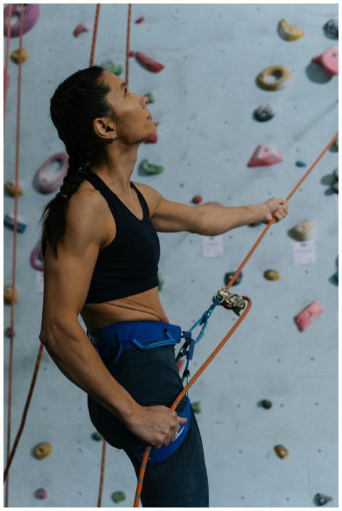 Asian woman engaged in indoor wall climbing, showc